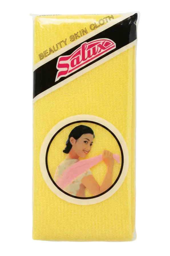A yellow Salux beauty skin cloth in its original plastic packaging, placed on a light brown wooden surface.