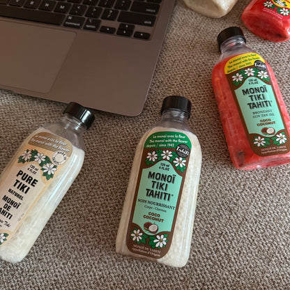 Bottles of Monoi Tiki Tahiti products on a wooden surface
