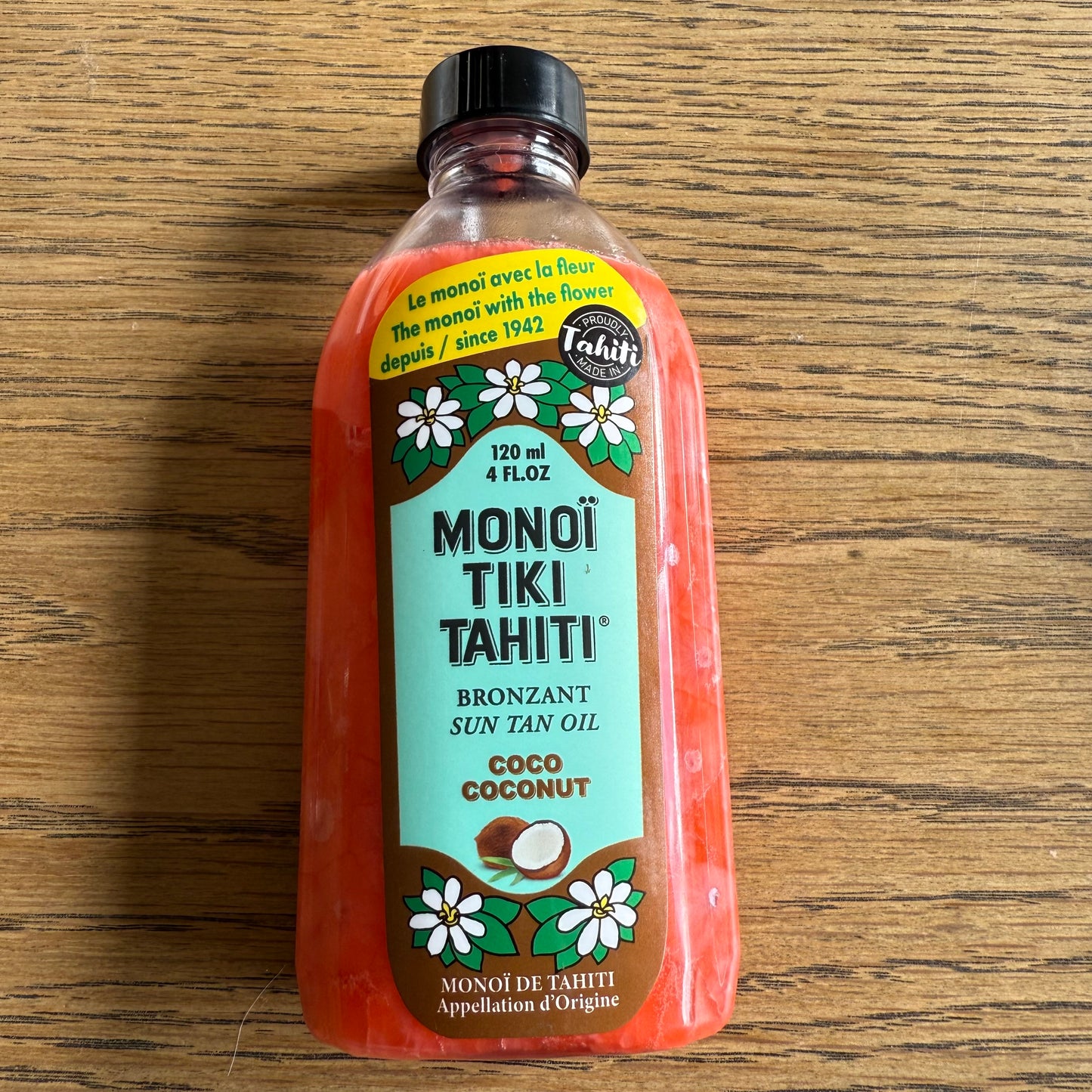 Bottles of Monoi Tiki Tahiti products on a wooden surface