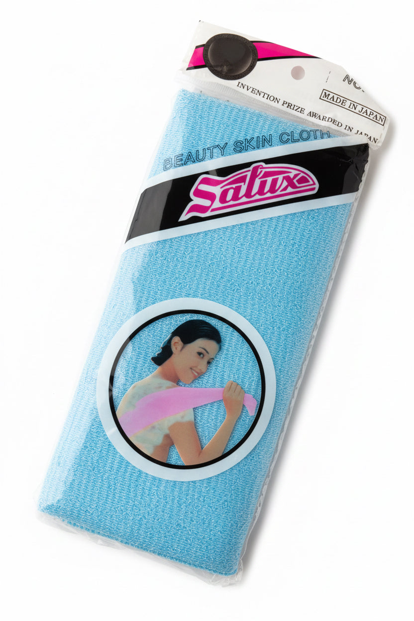 A packaged blue Satuse Beauty Skin Glove on a wooden tabletop. The product is in its original plastic packaging with a cardboard header and a circular graphic label showing a woman holding the glove.