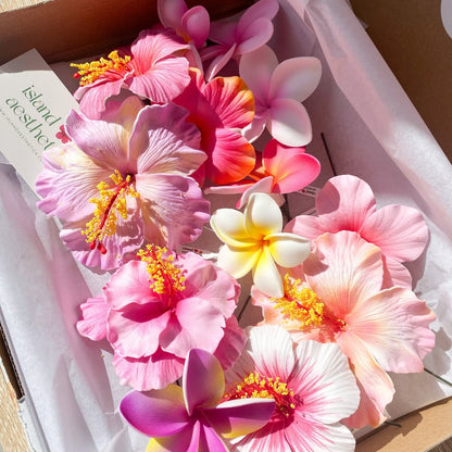 Colorful artificial flowers arranged in a box on a white background